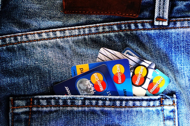 Credit cards peeking out of a jeans pocket.